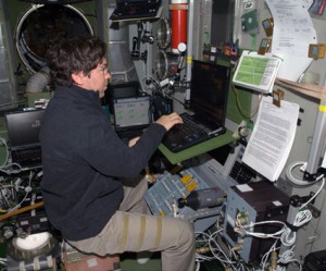 160328main_iss020e017368 Expedition 20 Flight Engineer Mike Barratt uses a computer in the Zvezda service module of the International Space Station. Credit: NASA