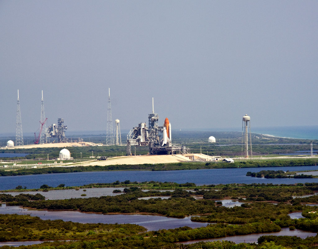 180842main_wide-angle-lg Photo taken on June 16, 2009, space shuttle Endeavour (center) is on launch Pad 39A midday after a scrubbed launch attempt. On the left is Launch Pad 39B, surrounded by lightning towers, which will be used for the Constellation Program. Image credit: NASA/Jack Pfaller