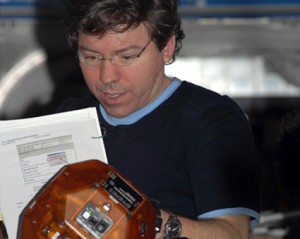 160328main_iss020e018315 Expedition 20 Flight Engineer Michael Barratt reads a checklist while working with the Synchronized Position Hold, Engage, Reorient, Experimental Satellites experiment in the Destiny laboratory of the International Space Station. Credit: NASA