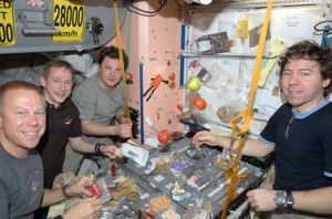 160328main_iss020e026767 Expedition 20 flight engineers Tim Kopra (left), Frank De Winne, Roman Romanenko and Michael Barratt share a meal at a galley in the Unity node of the International Space Station. Credit: NASA