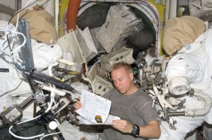 160328main_iss020e030458 Astronaut Tim Kopra, Expedition 20 flight engineer, looks over a checklist in the Quest airlock of the International Space Station. Credit: NASA
