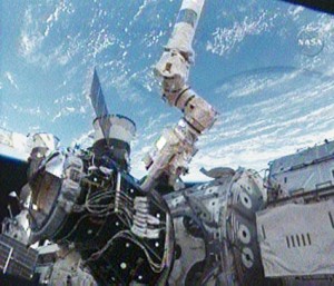 160328main_pma3_grapple The Canadarm2 positions the pressurized mating adapter before attaching it to the port side of the Unity Node. Credit: NASA TV