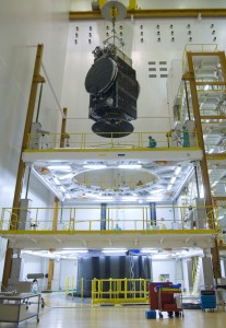 620_lg JCSAT-12 is lowered for its installation atop Ariane 5’s SYLDA payload dispenser, which is the black cylindrical-shaped structure visible at floor level.