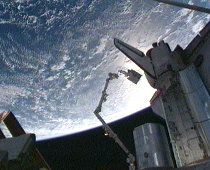160328main_425x345 Riding the station’s robotic arm, STS-128 Mission Specialist Christer Fuglesang moves an empty tank assembly into the shuttle’s cargo bay. Credit: NASA TV