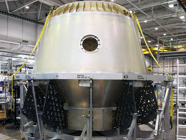 20090922_dragonflt Radial bulkheads being installed on the completed pressure vessel for the first COTS Dragon spacecraft. The bays between the bulkheads house Draco thrusters, propellant tanks, parachutes and other vital systems.