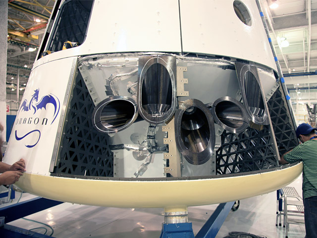 20090922_dragonpanels The Dragon qualification unit being outfitted with test Draco thruster housings. Depending on mission requirements, Dragon will carry as many as eighteen Draco thrusters per capsule.