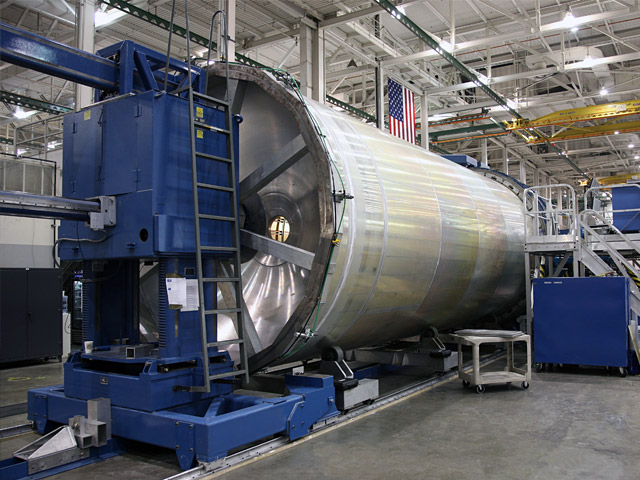 20090922_firststage Elsewhere in our Hawthorne plant, the launch vehicle for the second Falcon 9 flight is well underway. On the Friction Stir Welding (FSW) machine (above), the first stage tank passed the mid-point with the completion of the fuel tank welding.
