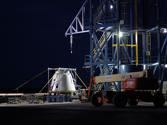 20090922_loadtest2 Dragon with temporary frame installed over it to measure deflections at the ISS docking interface.