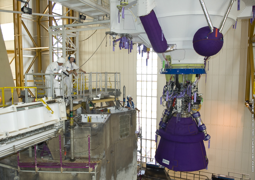 Hissage EPC This close-up photo details the Vulcain 2 engine as the core cryogenic stage is moved toward one of two mobile launch tables for Ariane 5. The other launch table currently is in the Spaceport’s Final Assembly Building, on which the Ariane 5 for Arianespace’s late September mission is awaiting the installation of its dual-satellite payload.