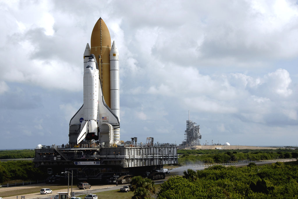 At NASA's Kennedy Space Center in Florida, the crawlerway is sprayed with water to minimize the dust cloud generated by the passing of the crawler-transporter. Space shuttle Atlantis is making its 3.4-mile trek from the Vehicle Assembly Building to Launch Pad 39A in the background. Credit: NASA At NASA's Kennedy Space Center in Florida, the crawlerway is sprayed with water to minimize the dust cloud generated by the passing of the crawler-transporter. Space shuttle Atlantis is making its 3.4-mile trek from the Vehicle Assembly Building to Launch Pad 39A in the background. Credit: NASA