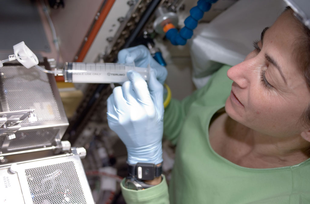 Nicole Stott, using a watering syringe. Credit: NASA Nicole Stott, using a watering syringe. Credit: NASA