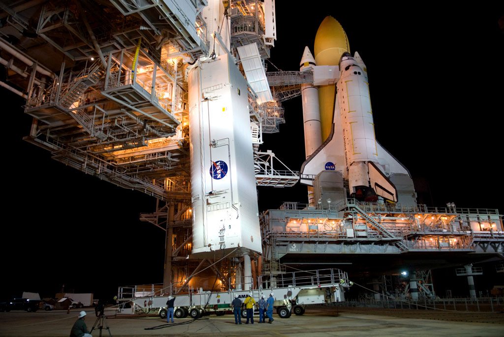 workers monitor the lift of the canister containing the payload for space shuttle Atlantis' STS-129 mission to the International Space Station - Express Logistics Carriers 1 and 2 - toward the Payload Changeout Room at Launch Pad 39A. Credit: NASA workers monitor the lift of the canister containing the payload for space shuttle Atlantis' STS-129 mission to the International Space Station - Express Logistics Carriers 1 and 2 - toward the Payload Changeout Room at Launch Pad 39A. Credit: NASA
