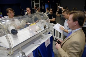 Independent inventor Peter Homer, left, founder of Flagsuit LLC, inserts a glove which he designed into a glove box for a demonstration of its dexterity and flexibility during the 2009 Astronaut Glove Challenge. Credit: NASA Independent inventor Peter Homer, left, founder of Flagsuit LLC, inserts a glove which he designed into a glove box for a demonstration of its dexterity and flexibility during the 2009 Astronaut Glove Challenge. Credit: NASA