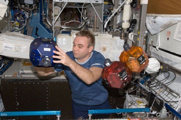 Flight Engineer Maxim Suraev performs a check of the Synchronized Position Hold, Engage, Reorient, Experimental Satellites (SPHERES) Beacon / Beacon Tester in the Destiny laboratory of the International Space Station. Photo credit: NASA Flight Engineer Maxim Suraev performs a check of the Synchronized Position Hold, Engage, Reorient, Experimental Satellites (SPHERES) Beacon / Beacon Tester in the Destiny laboratory of the International Space Station. Photo credit: NASA
