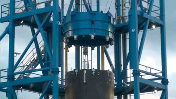 The Falcon 9 interstage (black cylinder at lower center) pushes away the simulated second stage (blue cylinder above). A series of restraining cables and counterweights capture the load and prevent it from falling downwards. Credit: SpaceX The Falcon 9 interstage (black cylinder at lower center) pushes away the simulated second stage (blue cylinder above). A series of restraining cables and counterweights capture the load and prevent it from falling downwards. Credit: SpaceX