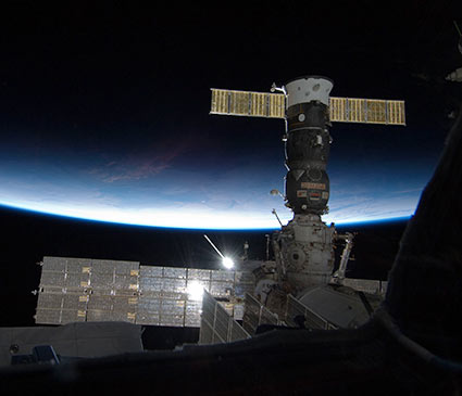 With Earth’s limb in the background, the Poisk module and a docked Progress cargo craft are seen from the International Space Station’s newly installed cupola. Credit: NASA With Earth’s limb in the background, the Poisk module and a docked Progress cargo craft are seen from the International Space Station’s newly installed cupola. Credit: NASA