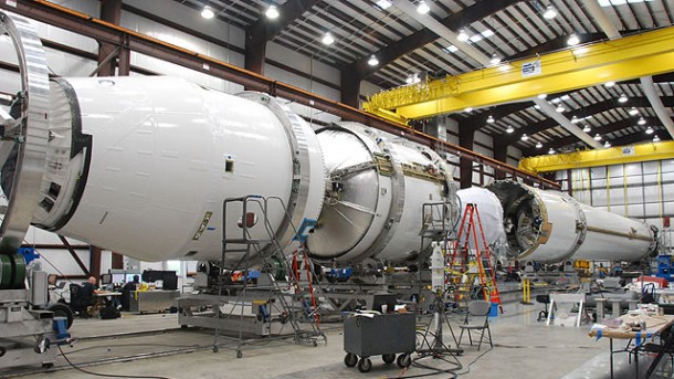 Flight hardware for the inaugural launch of Falcon 9 rocket undergoing final integration in the hangar at SpaceX's Cape Canaveral launch site in Florida. Components include: Dragon spacecraft qualification unit (left), second stage with Merlin Vacuum engine (center), first stage with nine Merlin 1C engines (right). Credit: SpaceX Flight hardware for the inaugural launch of Falcon 9 rocket undergoing final integration in the hangar at SpaceX's Cape Canaveral launch site in Florida. Components include: Dragon spacecraft qualification unit (left), second stage with Merlin Vacuum engine (center), first stage with nine Merlin 1C engines (right). Credit: SpaceX
