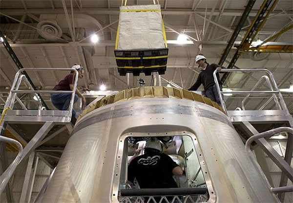 Loading a large M03 standard cargo module into the Dragon spacecraft via the overhead hatch (top of capsule). Credit: SpaceX Loading a large M03 standard cargo module into the Dragon spacecraft via the overhead hatch (top of capsule). Credit: SpaceX