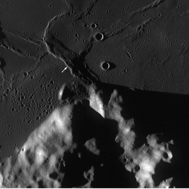 A WAC monochrome image centered on the Crisium Constellation region of interest. The highlands area in the south is the rim of the Crisium impact basin and wrinkle ridges and a wrinkle-ridge ring can be seen in the mare to the north. Arrow shows the location of the NAC frame above. Scene is 62 km across; image number M117107778ME Credit: NASA/GSFC/Arizona State University A WAC monochrome image centered on the Crisium Constellation region of interest. The highlands area in the south is the rim of the Crisium impact basin and wrinkle ridges and a wrinkle-ridge ring can be seen in the mare to the north. Arrow shows the location of the NAC frame above. Scene is 62 km across; image number M117107778ME Credit: NASA/GSFC/Arizona State University