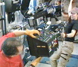 Flight Engineers Tracy Caldwell Dyson (right) and Soichi Noguchi remove the Robotics Work Station from the Destiny laboratory and transfer it to the cupola. Credit: NASA TV Flight Engineers Tracy Caldwell Dyson (right) and Soichi Noguchi remove the Robotics Work Station from the Destiny laboratory and transfer it to the cupola. Credit: NASA TV