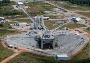 An aerial view offers an excellent perspective of the Soyuz launch site, including the launcher integration building in the background, along with the mobile gantry and launch pad in the foreground. The launch pad is positioned over a 149-meter-wide X 123-meter-long flame duct, which was excavated into layers of soil and granite at the Spaceport. An aerial view offers an excellent perspective of the Soyuz launch site, including the launcher integration building in the background, along with the mobile gantry and launch pad in the foreground. The launch pad is positioned over a 149-meter-wide X 123-meter-long flame duct, which was excavated into layers of soil and granite at the Spaceport.