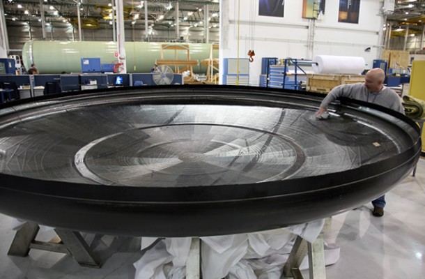 Inspecting the carbon-composite carrier structure for the first Dragon spacecraft heat shield, fresh from its mold. At nearly 4 meters (13 feet) in diameter, the structure supports the PICA-X tiles that protect the spacecraft during reentry. Credit: SpaceX. Inspecting the carbon-composite carrier structure for the first Dragon spacecraft heat shield, fresh from its mold. At nearly 4 meters (13 feet) in diameter, the structure supports the PICA-X tiles that protect the spacecraft during reentry. Credit: SpaceX.