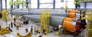 In this photo, two of the four strap-on boosters have been mated to the Soyuz’ Block A core stage during activity in the Launcher Integration Building at Europe’s Spaceport. Installation of the four strap-ons was completed this weekend. In this photo, two of the four strap-on boosters have been mated to the Soyuz’ Block A core stage during activity in the Launcher Integration Building at Europe’s Spaceport. Installation of the four strap-ons was completed this weekend.