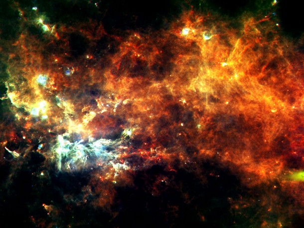 This image, in the constellation of Vulpecula, shows an entire assembly line of newborn stars. The diffuse glow reveals the widespread cold reservoir of raw material that our Galaxy has in stock for building stars. Credits: ESA/Hi-GAL Consortium This image, in the constellation of Vulpecula, shows an entire assembly line of newborn stars. The diffuse glow reveals the widespread cold reservoir of raw material that our Galaxy has in stock for building stars. Credits: ESA/Hi-GAL Consortium