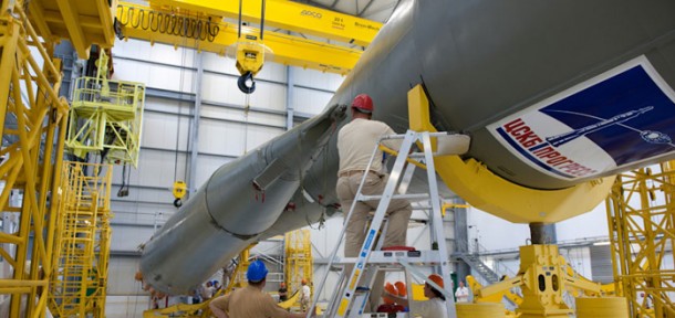 One of four strap-on boosters that make up Soyuz’ first stage is readied for mating with the vehicle’s Block A second stage during assembly checkout in the Spaceport’s Launcher Integration Building. Visible on the Block A stage’s forward portion is the logo of Russia’s TsSKB-Progress, which produces the launcher at its facility in Samara. One of four strap-on boosters that make up Soyuz’ first stage is readied for mating with the vehicle’s Block A second stage during assembly checkout in the Spaceport’s Launcher Integration Building. Visible on the Block A stage’s forward portion is the logo of Russia’s TsSKB-Progress, which produces the launcher at its facility in Samara.