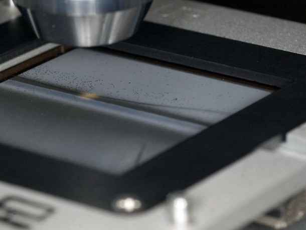 This photograph shows microshutters being examined with a microscope. A hair is visible in the picture for size comparison. Credit: NASA/Chris Gunn This photograph shows microshutters being examined with a microscope. A hair is visible in the picture for size comparison. Credit: NASA/Chris Gunn