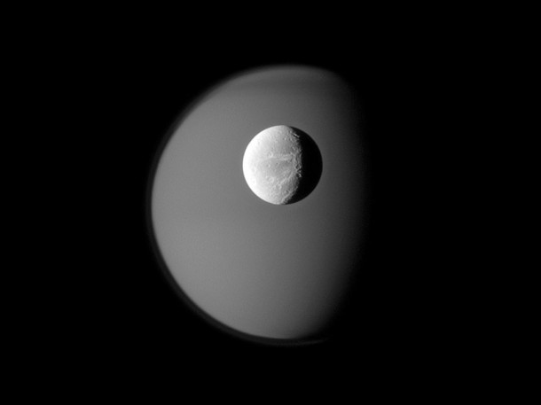 The surface of Saturn's moon Dione is rendered in crisp detail against a hazy, ghostly Titan. Credit: NASA/JPL/Space Science Institute The surface of Saturn's moon Dione is rendered in crisp detail against a hazy, ghostly Titan. Credit: NASA/JPL/Space Science Institute
