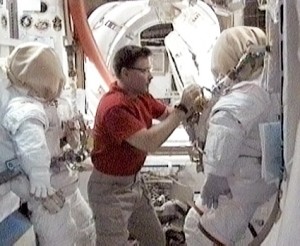 Flight Engineer Doug Wheelock configures spacesuits inside the Quest airlock of the International Space Station. Credit: NASA TV Flight Engineer Doug Wheelock configures spacesuits inside the Quest airlock of the International Space Station. Credit: NASA TV