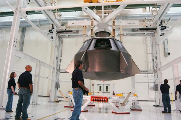 A production assembly crew lowers a full-scale Orion mockup onto the crew module holding structure during an assembly pathfinding maneuver at the Operations & Checkout Facility at NASA's Kennedy Space Center in Florida. Image Credit: NASA A production assembly crew lowers a full-scale Orion mockup onto the crew module holding structure during an assembly pathfinding maneuver at the Operations & Checkout Facility at NASA's Kennedy Space Center in Florida. Image Credit: NASA