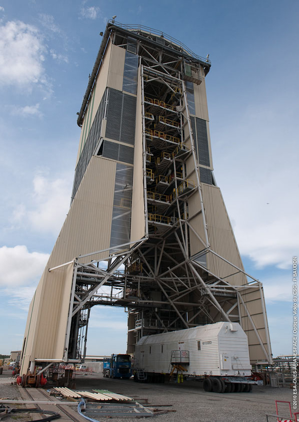 The hydrogen peroxide delivery vehicle is shown under the Soyuz gantry, which is positioned some 80 meters from the launch pad. Since the gantry is located in the primary axis from the Soyuz’ preparation area to the launch pad, this structure is designed to allow the hydrogen peroxide delivery vehicle – along with the kerosene supply rail car and the Soyuz launcher itself – to pass underneath on their separate rollouts to the launch table. The hydrogen peroxide delivery vehicle is shown under the Soyuz gantry, which is positioned some 80 meters from the launch pad. Since the gantry is located in the primary axis from the Soyuz’ preparation area to the launch pad, this structure is designed to allow the hydrogen peroxide delivery vehicle – along with the kerosene supply rail car and the Soyuz launcher itself – to pass underneath on their separate rollouts to the launch table.