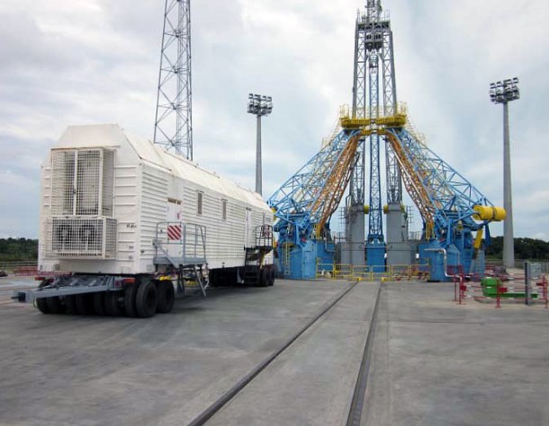 In this image, the hydrogen peroxide delivery vehicle is shown where it will be parked on the launch pad to supply a Soyuz launcher, which is to be erected in the background. The hydrogen peroxide vehicle is one of three delivery systems that will move into the launch zone during final Soyuz preparations. The others are a rail car with kerosene (which is to travel along the tracks visible in the photo’s center), and a dedicated wheeled container with kerosene to supply the Soyuz’ Block I third stage. All other fluids and propellant supplied to Soyuz will be delivered through pipes that are built into the launch pad. In this image, the hydrogen peroxide delivery vehicle is shown where it will be parked on the launch pad to supply a Soyuz launcher, which is to be erected in the background. The hydrogen peroxide vehicle is one of three delivery systems that will move into the launch zone during final Soyuz preparations. The others are a rail car with kerosene (which is to travel along the tracks visible in the photo’s center), and a dedicated wheeled container with kerosene to supply the Soyuz’ Block I third stage. All other fluids and propellant supplied to Soyuz will be delivered through pipes that are built into the launch pad.