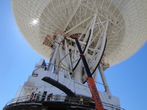 Under the unflinching summer sun, workers at NASA's Deep Space Network complex in Goldstone, Calif., use a crane to lift a runner segment that is part of major surgery on a giant, 70-meter-wide antenna. Under the unflinching summer sun, workers at NASA's Deep Space Network complex in Goldstone, Calif., use a crane to lift a runner segment that is part of major surgery on a giant, 70-meter-wide antenna.