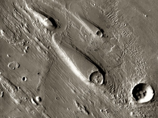 In Ares Vallis, teardrop mesas extend like pennants behind impact craters, where the raised rocky rims diverted the floods and protected the ground from erosion. Image credit: NASA/JPL-Caltech/ASU In Ares Vallis, teardrop mesas extend like pennants behind impact craters, where the raised rocky rims diverted the floods and protected the ground from erosion. Image credit: NASA/JPL-Caltech/ASU