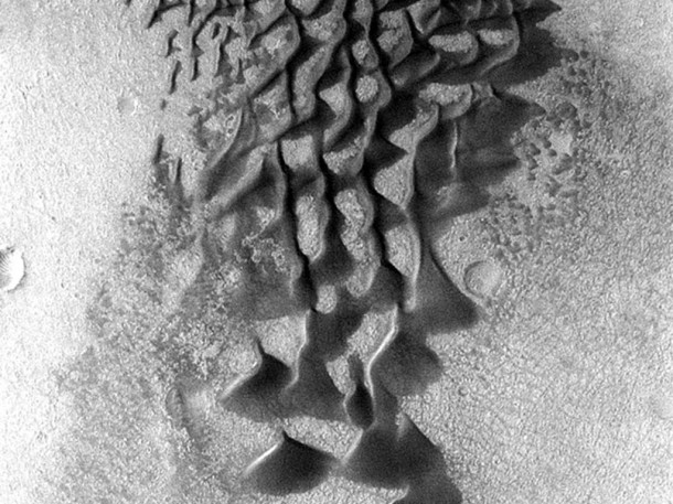 Fans and ribbons of dark sand dunes creep across the floor of Bunge Crater in response to winds blowing from the direction at the top of the picture. Image credit: NASA/JPL-Caltech/ASU Fans and ribbons of dark sand dunes creep across the floor of Bunge Crater in response to winds blowing from the direction at the top of the picture. Image credit: NASA/JPL-Caltech/ASU