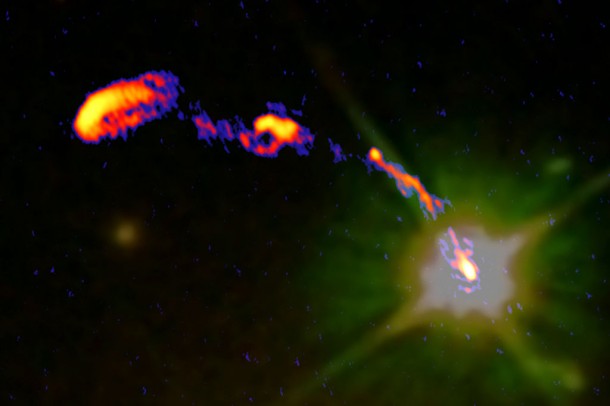 This is a composite of the new e-MERLIN radio image of the Double Quasar and an earlier Hubble Space Telescope (HST) optical image. One of the lensed quasar core images is visible at lower right. The radio emission generated by the black hole as seen with e-MERLIN is visible as the compact bright region superimposed on the (yellow-green) optical emission seen by HST. The radio jet, moving at speeds approaching that of light, is seen in the e-MERLIN image arcing away from the black hole towards the upper left. Credit: Jodrell Bank Centre for Astrophysics, University of Manchester This is a composite of the new e-MERLIN radio image of the Double Quasar and an earlier Hubble Space Telescope (HST) optical image. One of the lensed quasar core images is visible at lower right. The radio emission generated by the black hole as seen with e-MERLIN is visible as the compact bright region superimposed on the (yellow-green) optical emission seen by HST. The radio jet, moving at speeds approaching that of light, is seen in the e-MERLIN image arcing away from the black hole towards the upper left. Credit: Jodrell Bank Centre for Astrophysics, University of Manchester