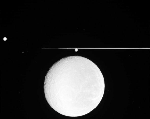 NASA's Cassini spacecraft captured this image showing Saturn's icy moon Rhea taking center stage, with cameo appearances by Saturn's rings and three clearly visible moons. Image credit: NASA/JPL/SSI NASA's Cassini spacecraft captured this image showing Saturn's icy moon Rhea taking center stage, with cameo appearances by Saturn's rings and three clearly visible moons. Image credit: NASA/JPL/SSI