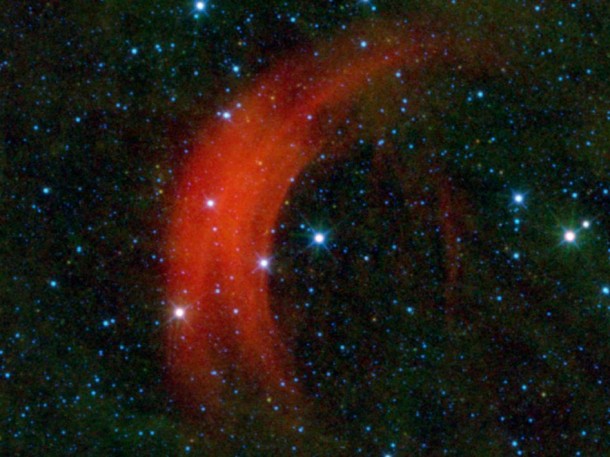 NASA's Wide-field Infrared Survey Explorer, or WISE, captured this image of the star Alpha Camelopardalis, or Alpha Cam, in astronomer-speak, speeding through the sky like a motorcyclist zipping through rush-hour traffic. The big red arc is a bow shock, similar to the wake in front of the bow of a ship in water. Credit: NASA/JPL-Caltech NASA's Wide-field Infrared Survey Explorer, or WISE, captured this image of the star Alpha Camelopardalis, or Alpha Cam, in astronomer-speak, speeding through the sky like a motorcyclist zipping through rush-hour traffic. The big red arc is a bow shock, similar to the wake in front of the bow of a ship in water. Credit: NASA/JPL-Caltech