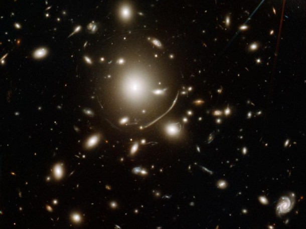 The giant cluster of elliptical galaxies in the center of this image contains so much dark matter mass that its gravity bends light. Image credit: NASA, ESA, CRAL, LAM, STScI The giant cluster of elliptical galaxies in the center of this image contains so much dark matter mass that its gravity bends light. Image credit: NASA, ESA, CRAL, LAM, STScI
