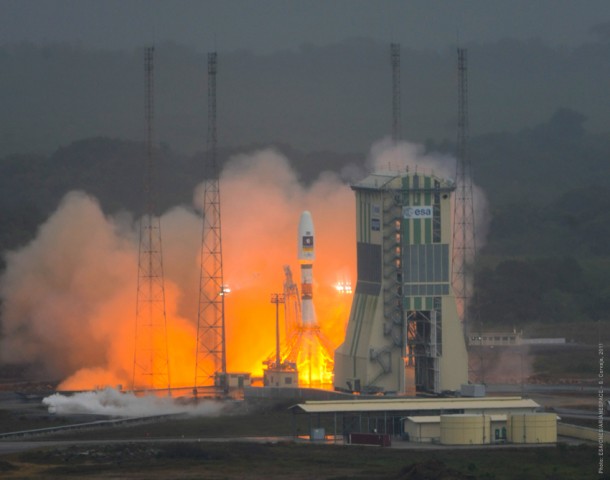 Transitioning from preliminary thrust level to its full thrust output while on the launch pad, the no. 1 Soyuz is seconds away from lifting off from French Guiana. Transitioning from preliminary thrust level to its full thrust output while on the launch pad, the no. 1 Soyuz is seconds away from lifting off from French Guiana.