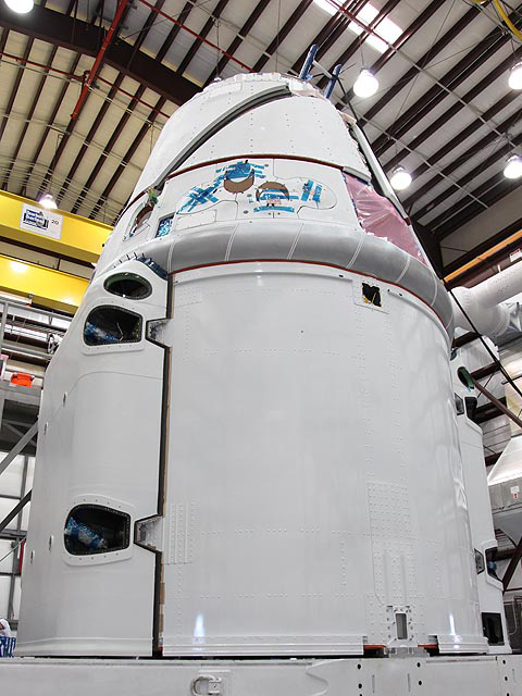 Dragon with the protective fairings installed over the folded solar arrays, at the SpaceX Cape Canaveral launch site. Dragon with the protective fairings installed over the folded solar arrays, at the SpaceX Cape Canaveral launch site.