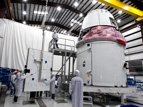 Dragon’s solar array panels being installed on Dragon’s trunk at the SpaceX hangar in Cape Canaveral, FL. Dragon’s solar array panels being installed on Dragon’s trunk at the SpaceX hangar in Cape Canaveral, FL.