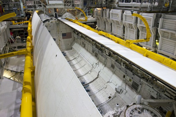 Discovery's payload bay doors swing shut with the aid of yellow-painted strongbacks. Photo credit: NASA/Kim Shiflett Discovery's payload bay doors swing shut with the aid of yellow-painted strongbacks. Photo credit: NASA/Kim Shiflett