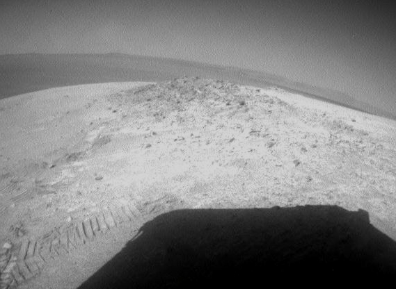 NASA's Mars Exploration Rover Opportunity drove about 12 feet (3.67 meters) on May 8, 2012, after spending 19 weeks working in one place while solar power was too low for driving during the Martian winter. The winter worksite was on the north slope of an outcrop called Greeley Haven. The rover used its rear hazard-avoidance camera after nearly completing the May 8 drive, capturing this view looking back at the Greeley Haven. The dark shape in the foreground is the shadow of Opportunity's solar array. The view is toward the southeast. Image Credit: NASA/JPL-Caltech NASA's Mars Exploration Rover Opportunity drove about 12 feet (3.67 meters) on May 8, 2012, after spending 19 weeks working in one place while solar power was too low for driving during the Martian winter. The winter worksite was on the north slope of an outcrop called Greeley Haven. The rover used its rear hazard-avoidance camera after nearly completing the May 8 drive, capturing this view looking back at the Greeley Haven. The dark shape in the foreground is the shadow of Opportunity's solar array. The view is toward the southeast. Image Credit: NASA/JPL-Caltech