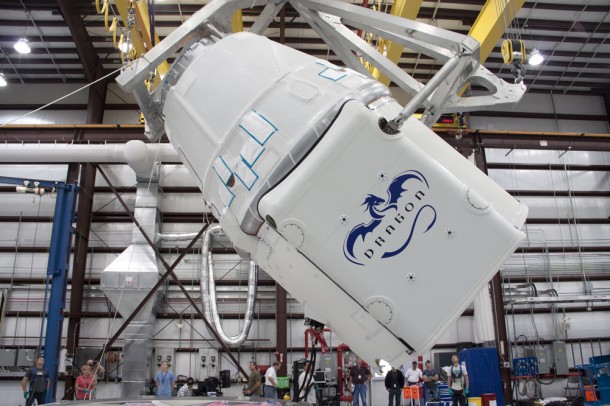 The Dragon capsule is rotated into position during processing ahead of its demonstration mission to the International Space Station. The spacecraft will launch into space aboard a Falcon 9 rocket. Both the launcher and spacecraft are made by SpaceX. Photo credit: NASA/Jim Grossmann The Dragon capsule is rotated into position during processing ahead of its demonstration mission to the International Space Station. The spacecraft will launch into space aboard a Falcon 9 rocket. Both the launcher and spacecraft are made by SpaceX. Photo credit: NASA/Jim Grossmann