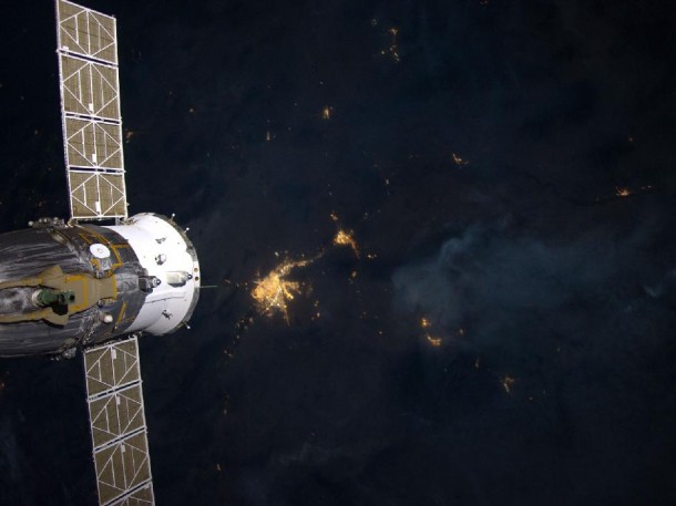 The flame-ring associated with wild fires in the Southwest can be seen in the upper right of this image taken aboard the International Space Station, while the lights of El Paso-Las Cruces rise from the bottom center. A Russian spacecraft is seen docked to the station at left. Credit: NASA The flame-ring associated with wild fires in the Southwest can be seen in the upper right of this image taken aboard the International Space Station, while the lights of El Paso-Las Cruces rise from the bottom center. A Russian spacecraft is seen docked to the station at left. Credit: NASA