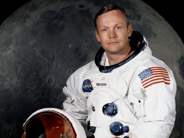 Portrait of Astronaut Neil A. Armstrong, commander of the Apollo 11 Lunar Landing mission in his space suit, with his helmet on the table in front of him. Behind him is a large photograph of the lunar surface. Image Credit: NASA Portrait of Astronaut Neil A. Armstrong, commander of the Apollo 11 Lunar Landing mission in his space suit, with his helmet on the table in front of him. Behind him is a large photograph of the lunar surface. Image Credit: NASA